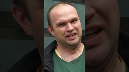 MĘŻCZYZNA SZOKUJE NA ULICY.  LUKSUSOWY SAMOCHÓD W TLE